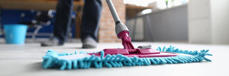 Mann mit Mopp wäscht Boden im Büro. Reinigung Unternehmen Dienstleistungen Konzept