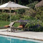 Sonnige Ruhezone im Garten mit Blick auf Stahlwandpool