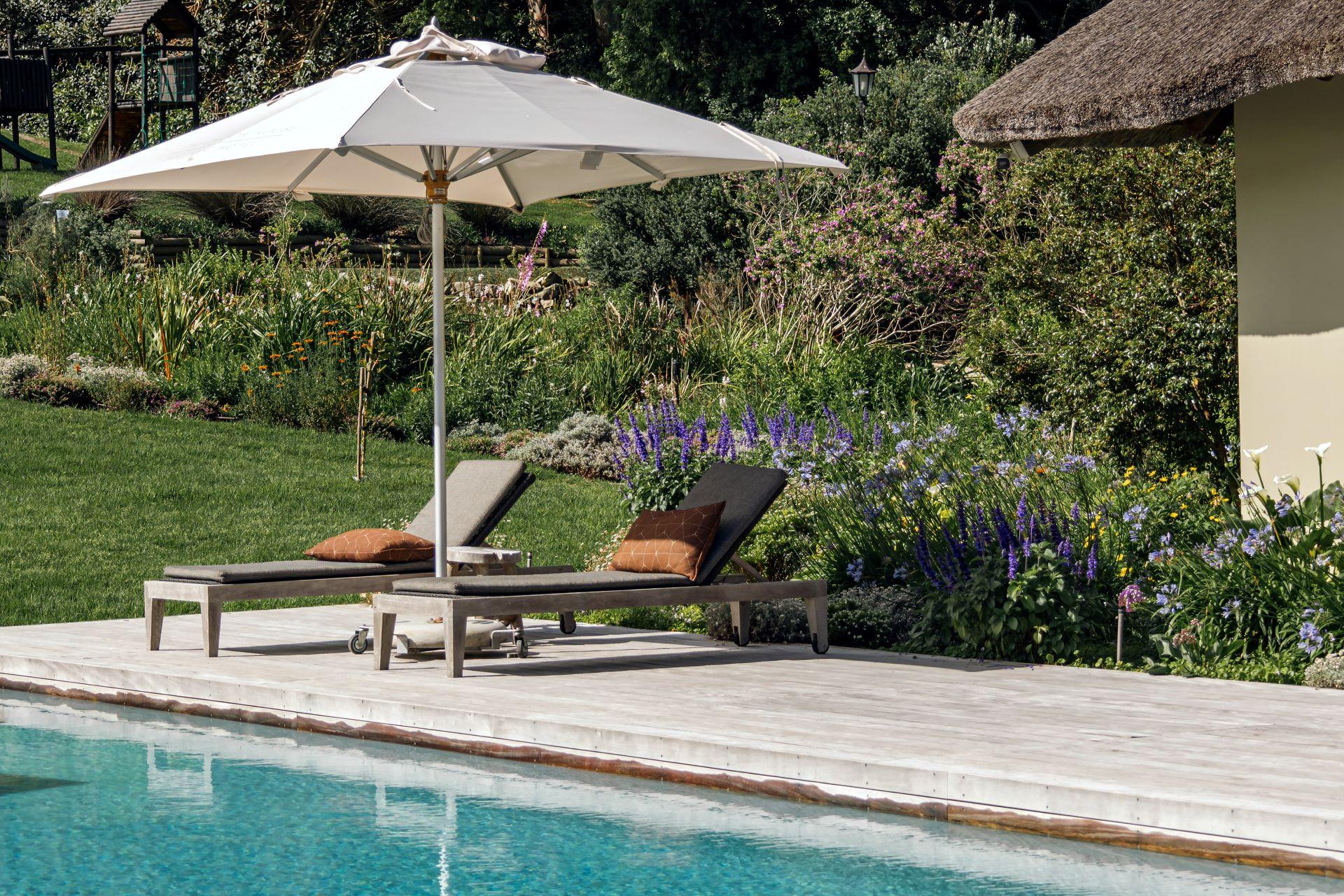 Sonnige Ruhezone im Garten mit Blick auf Stahlwandpool